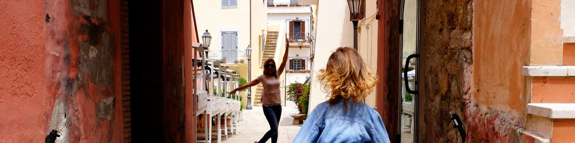 Little girl plays with her mother in a small and characteristic Italian village. San Felice Circeo, Lazio, Italy