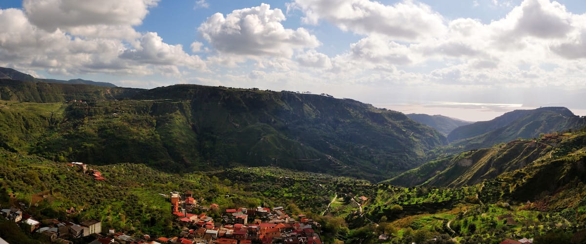 A mountainous landscape with a village nestled in the valley.