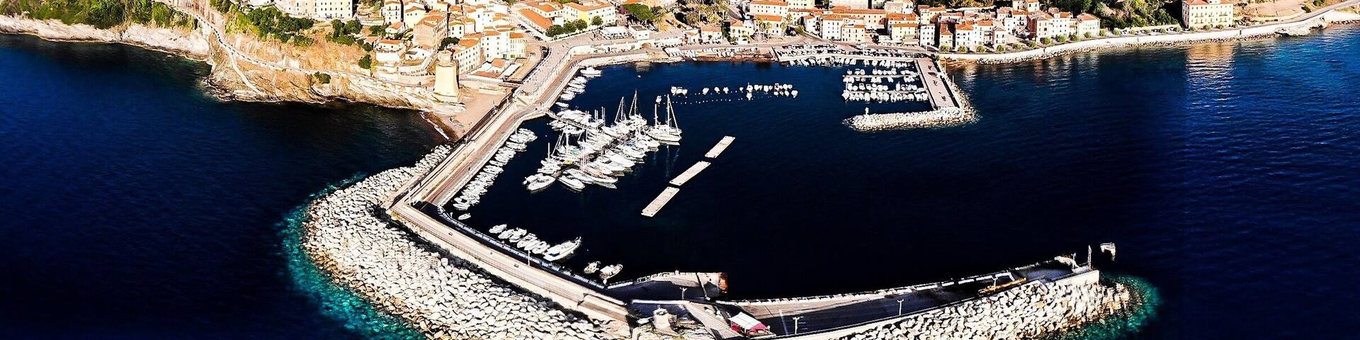 The town of Rio Marina is located on the eastern side of the Elba island, nestled gently in a small inlet surrounded by hills. In this area of the island, the coast that stretches from Rio Marina to Cavo is called the "Shining coast,” or “Costa che brilla” in Italian. This nickname was given to honor the almost dreamlike glint that comes from the black mining dust