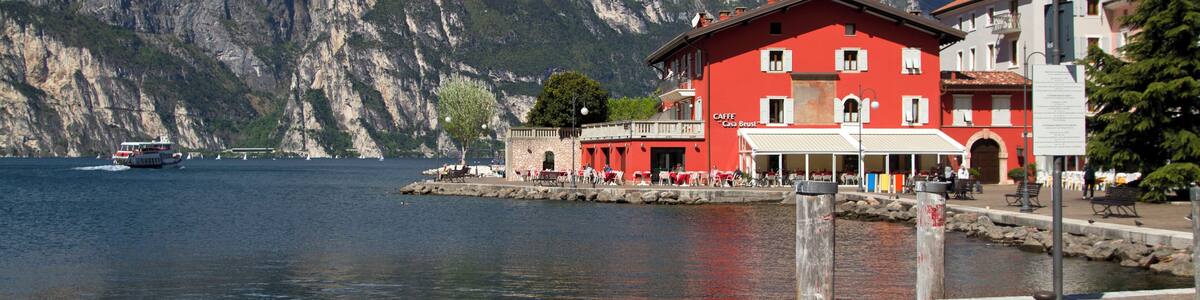 Ein See mit einem roten Gebäude und Bergen im Hintergrund.