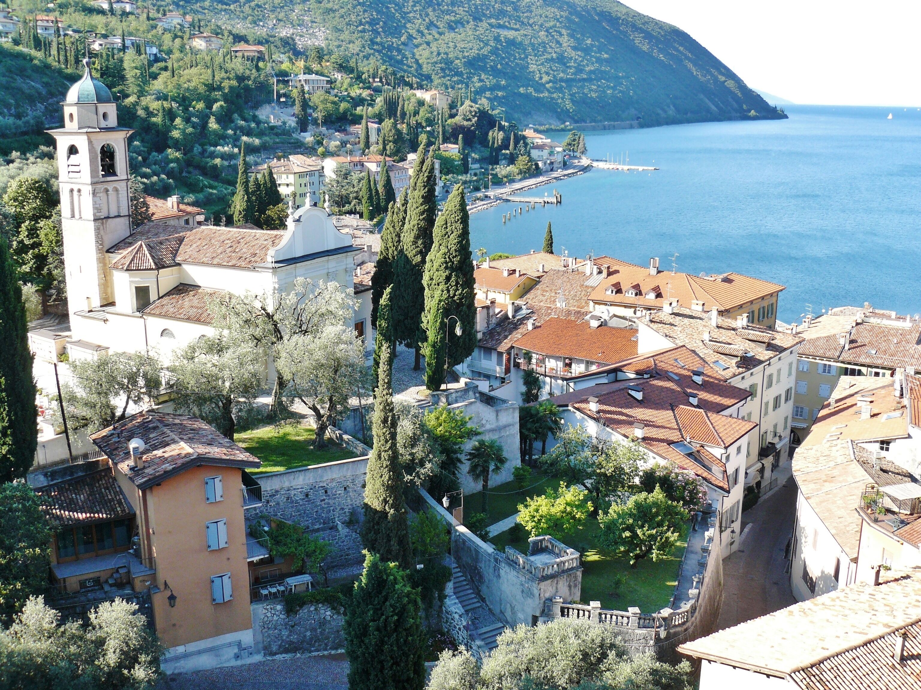 A coastal town with a prominent church tower, terraced houses, and a clear view of the sea.