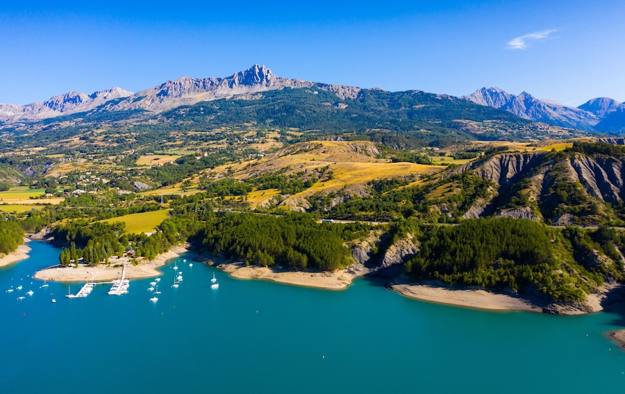 A coastal landscape with mountains, a marina, and a river.