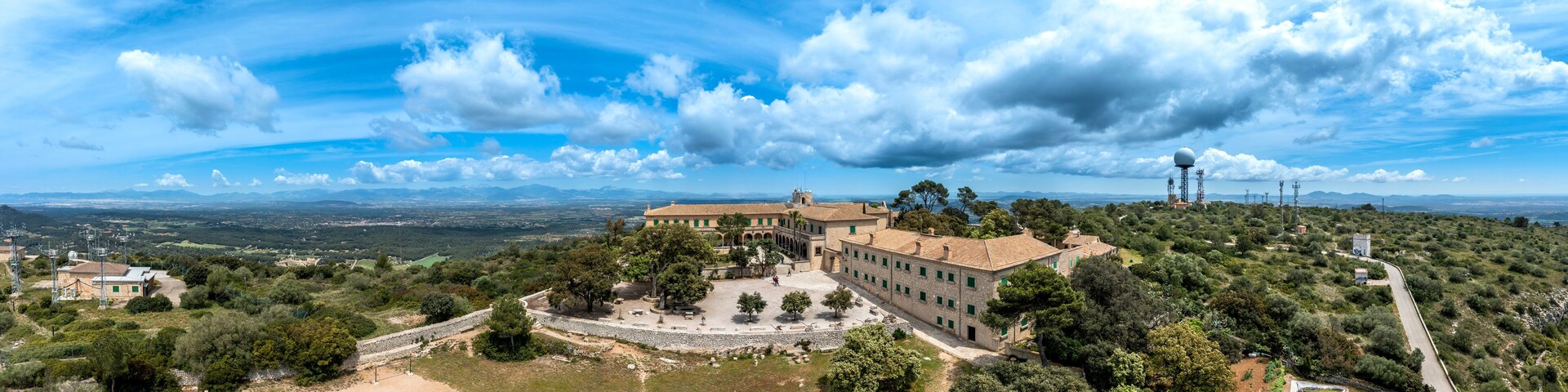 A historic building surrounded by trees and hills.