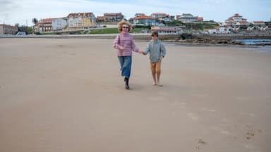 Mother and son joyfully running along a sandy beach on a winter trip