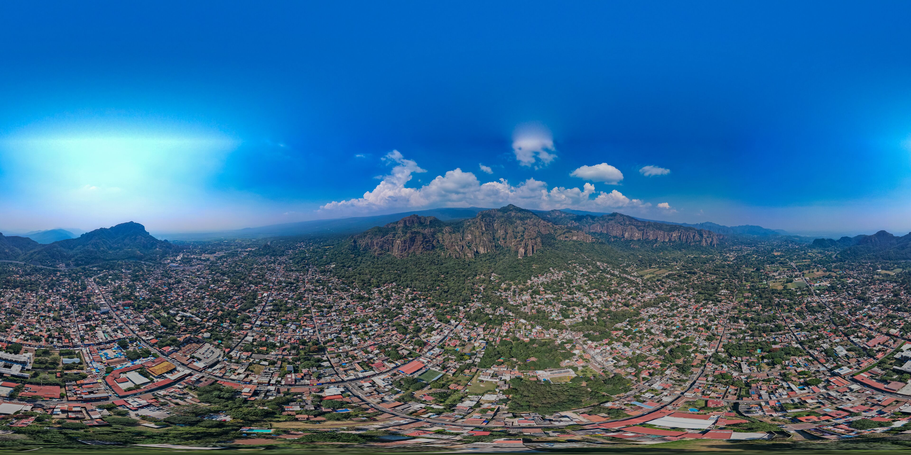 A panoramic view of a city with a mountain range in the background.