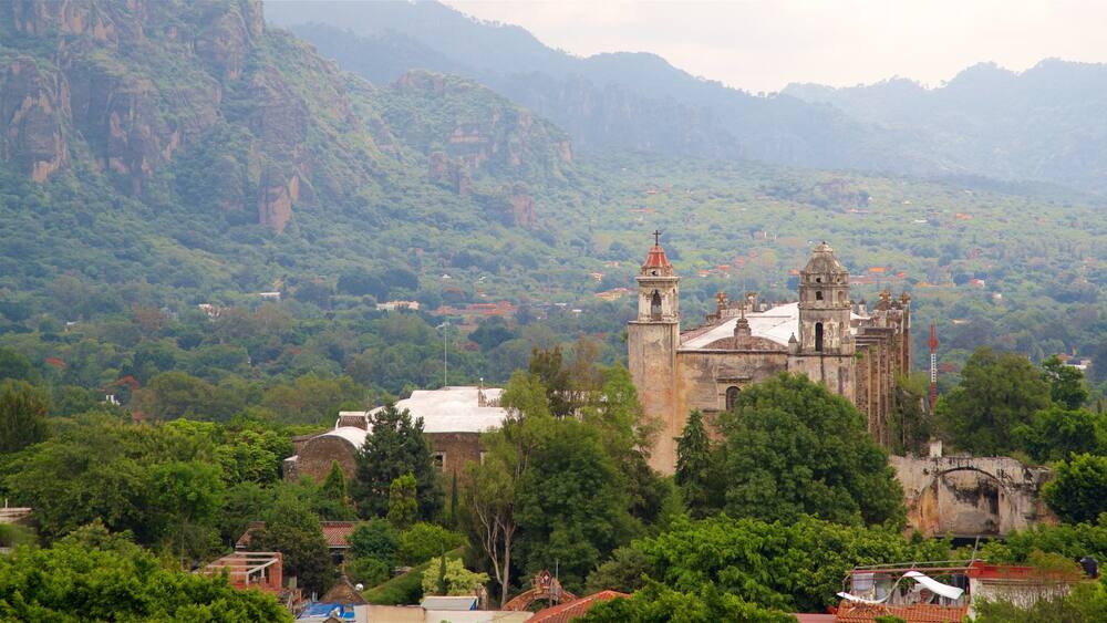 Une église historique, entourée d’une végétation luxuriante et de montagnes.