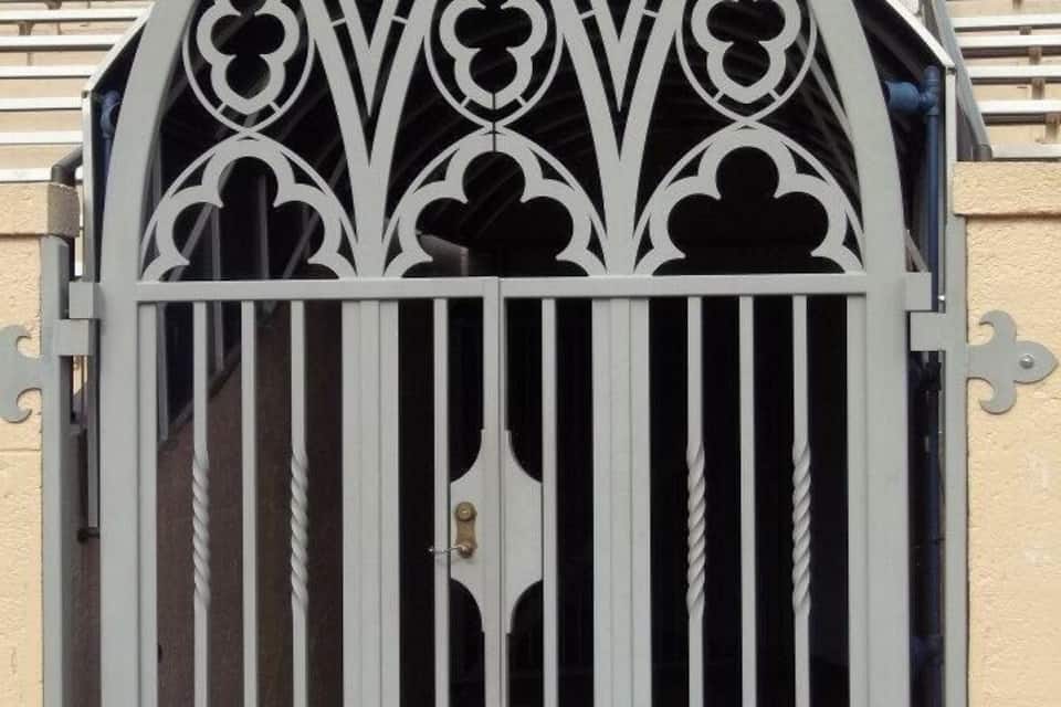 A gothic-style metal gate with the letter 'D' on it.