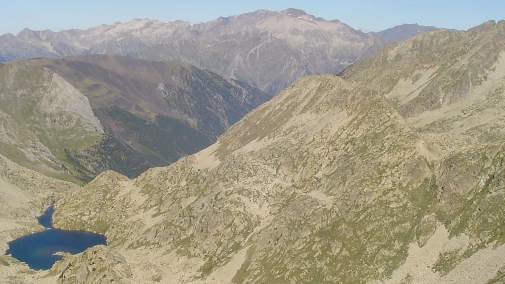 Un paysage montagneux avec deux lacs et, au loin, des sommets enneigés.