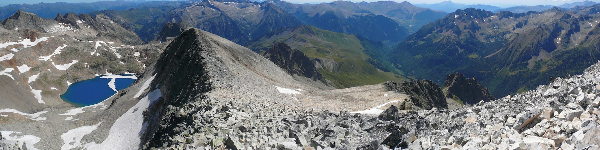 A mountain landscape with a prominent peak, rocky terrain, and a small lake.