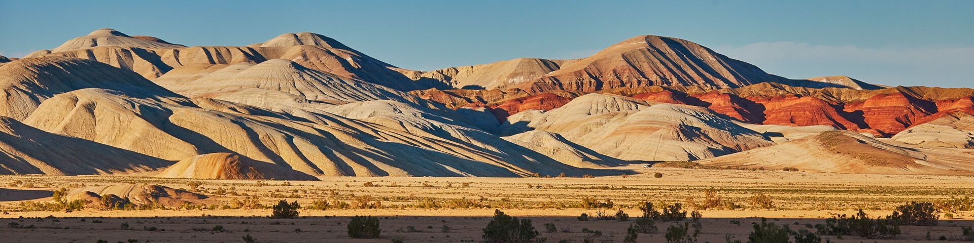 Un paisaje desértico con colinas onduladas y vegetación escasa.