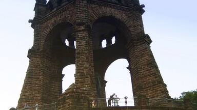 A large stone structure with arches and a central tower.