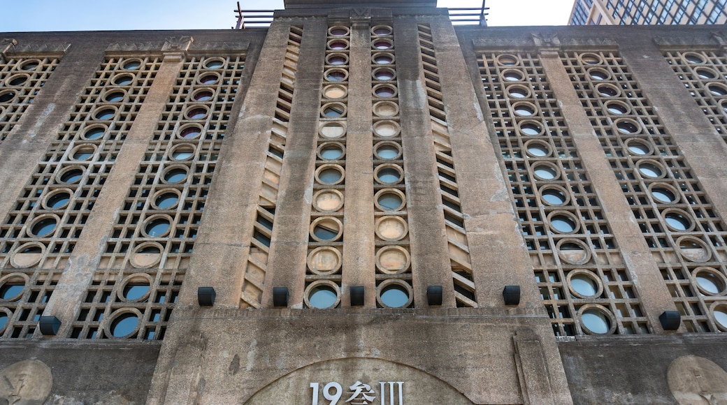 A building facade with circular windows and a central inscription.