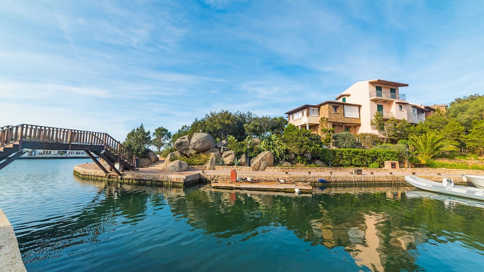 A waterfront property with a bridge, dock, and lush greenery.