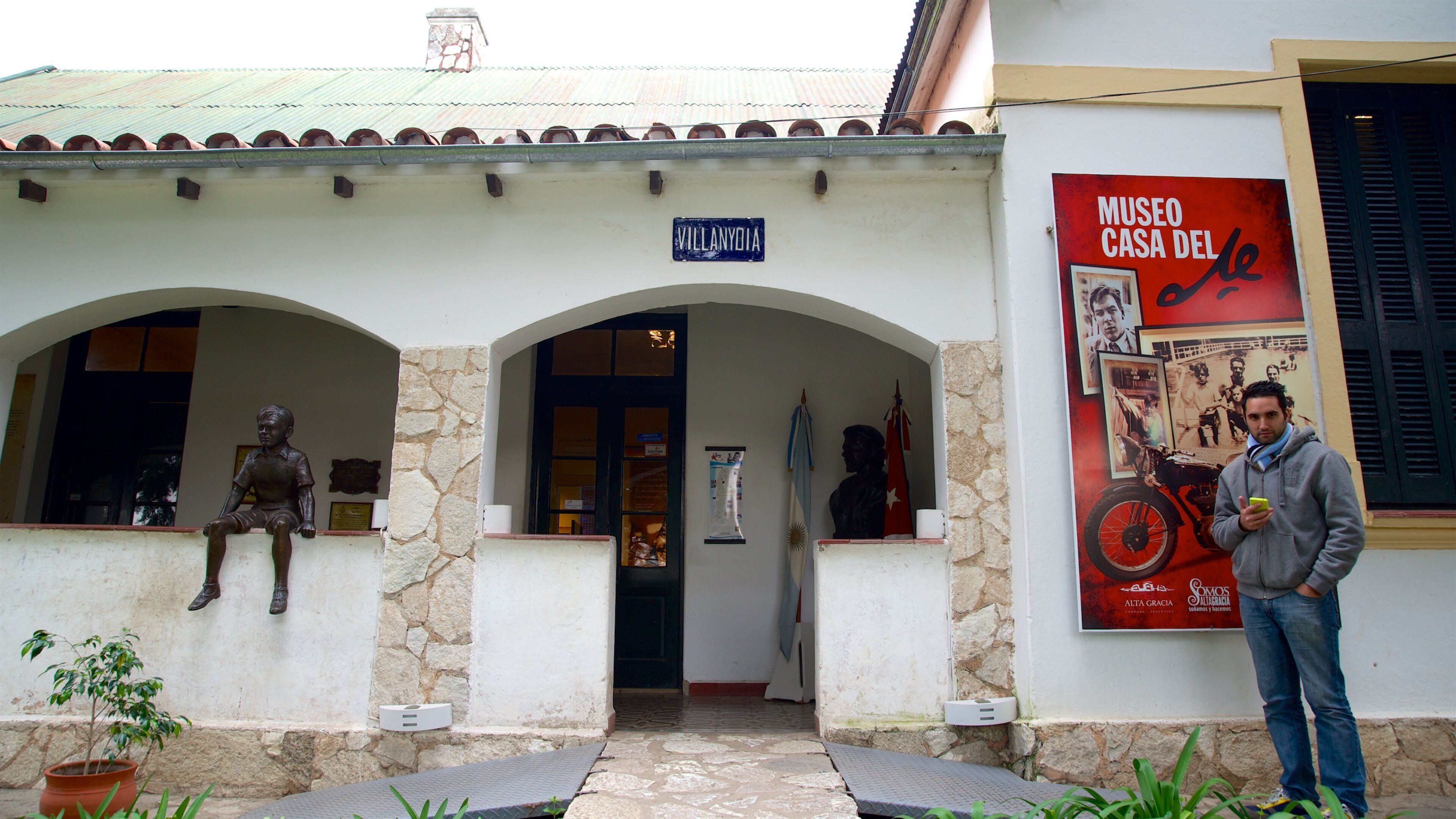 A building with a sign reading "Villanyoya" and a poster advertising "Museo Casa del".