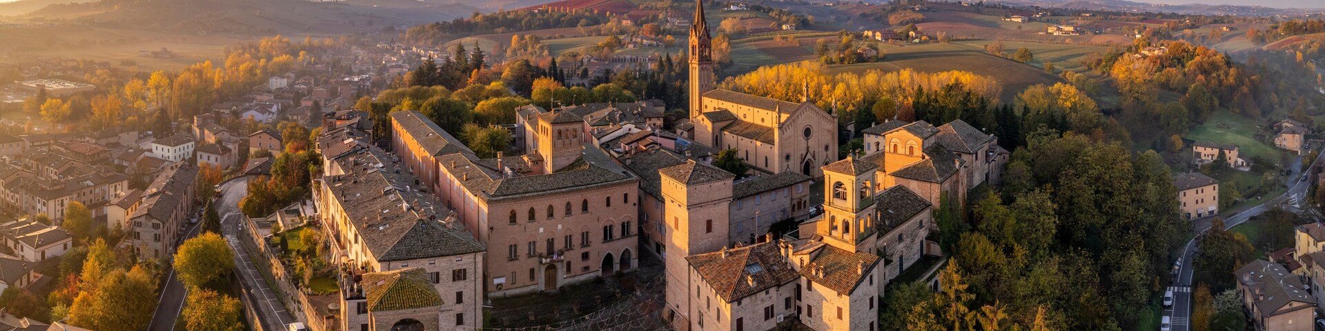 Lovevy aerial panoramic view of Castelvetro di Modena at sunrise among vineyards on Fall season