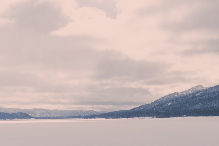 A forest mountain raises up from a snow-covered valley in a Donnelly, Idaho winter landscape
