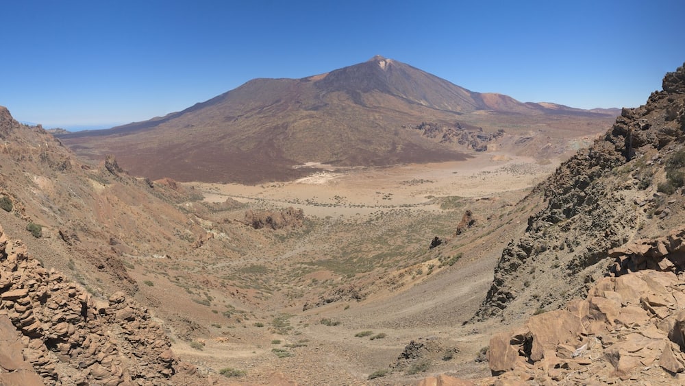 Un paysage montagneux accidenté, caractérisé par un terrain rocheux et une végétation clairsemée.