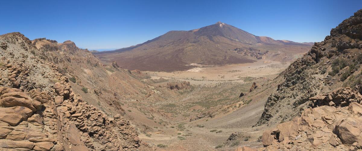 A rugged mountain landscape with rocky terrain and sparse vegetation.