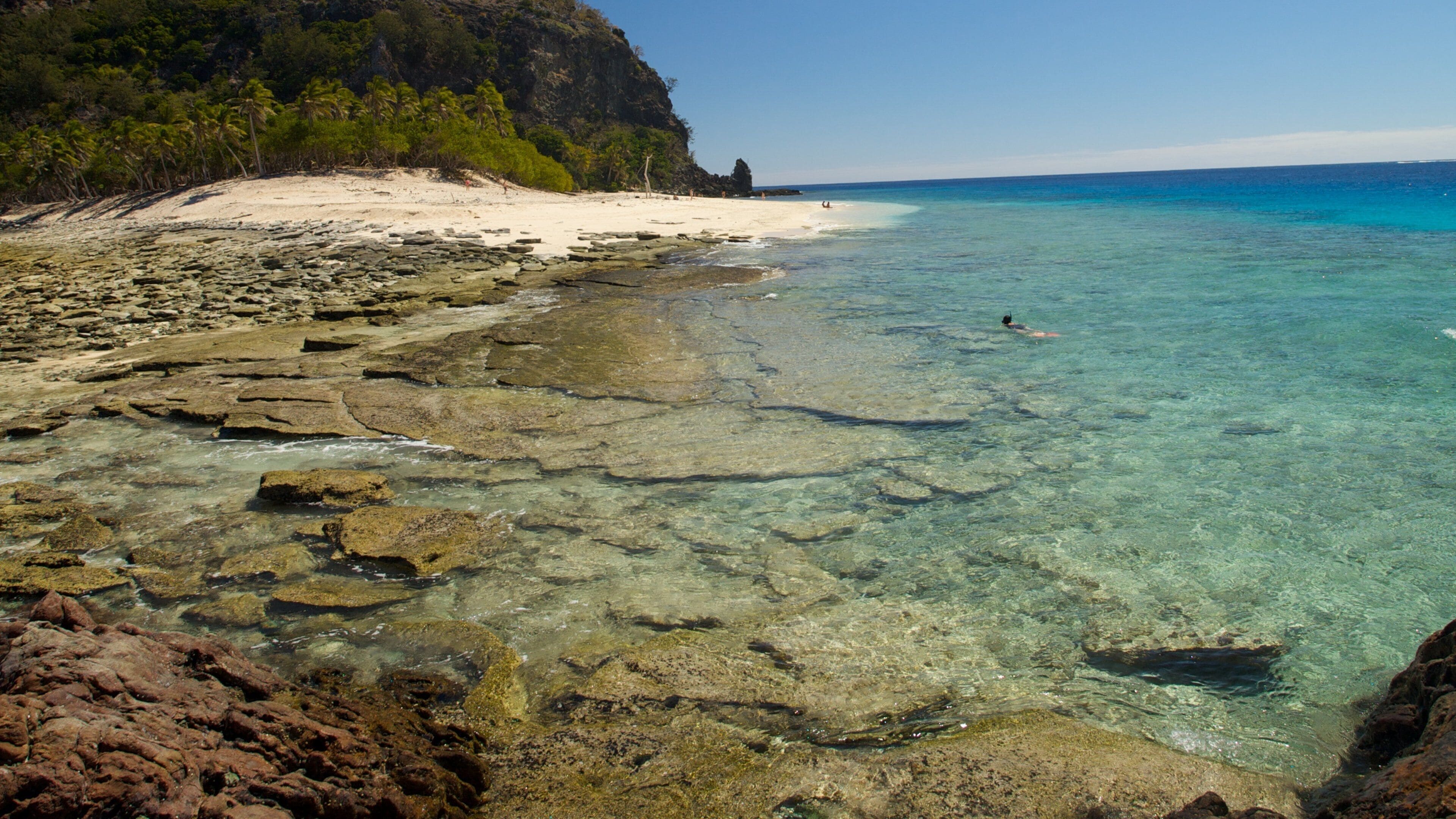 Islas Mamanuca que incluye litoral rocoso, una playa y escenas tropicales