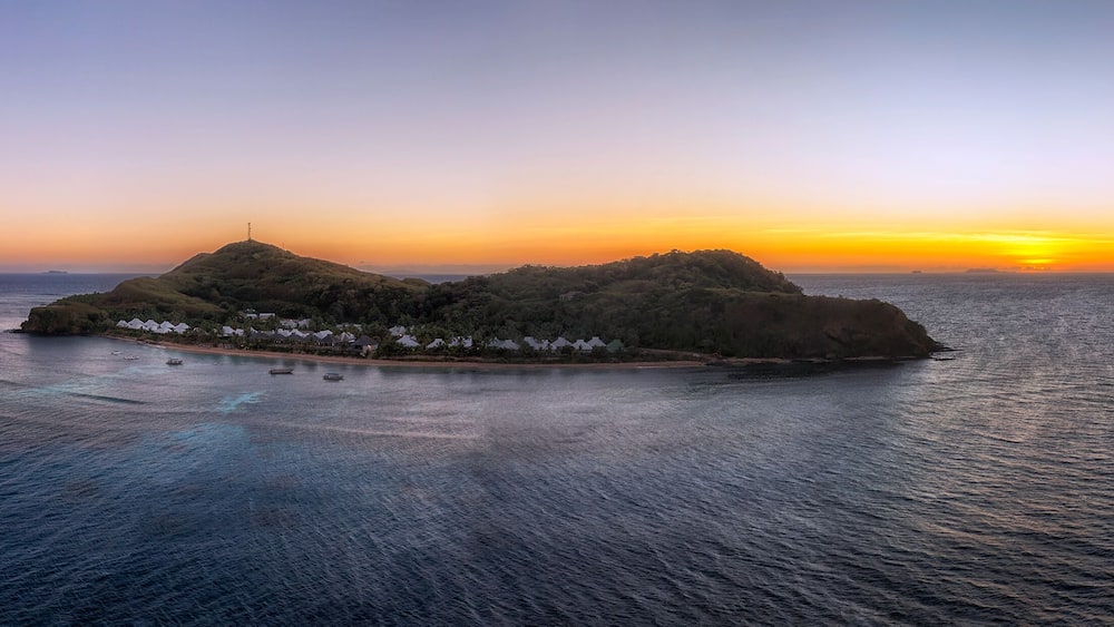 Une île tropicale avec un petit village, au coucher du soleil.