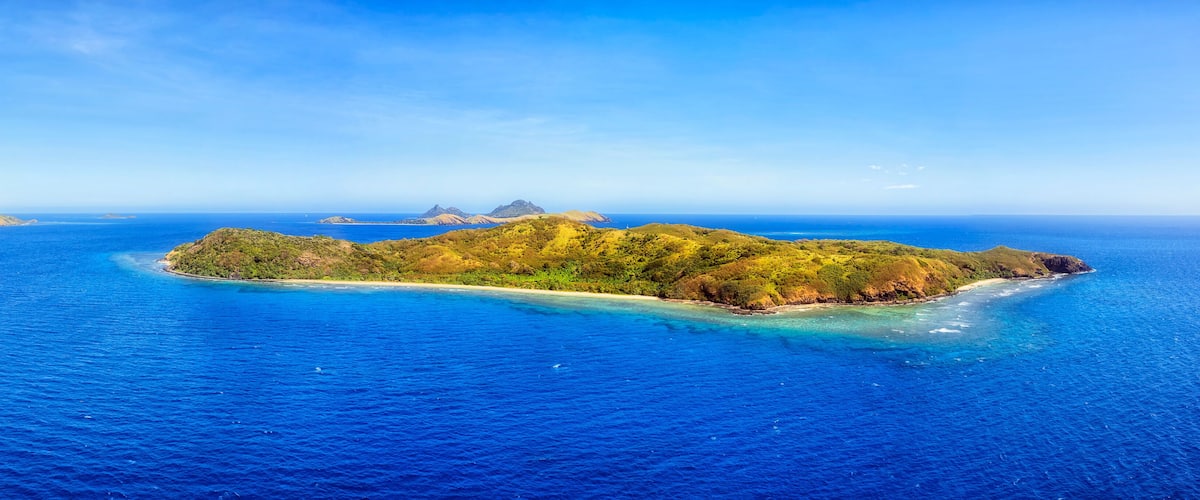 A tropical island surrounded by clear blue waters.