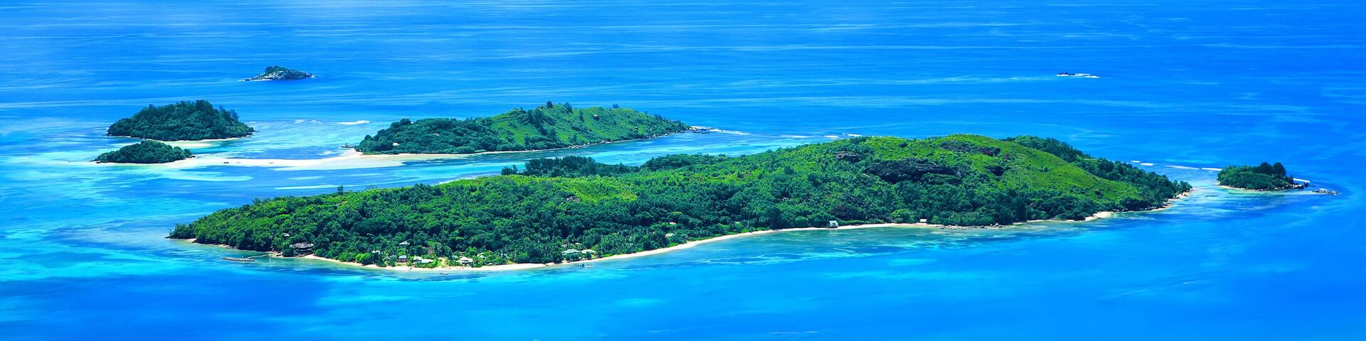 A tropical island archipelago with clear turquoise waters and lush green vegetation.