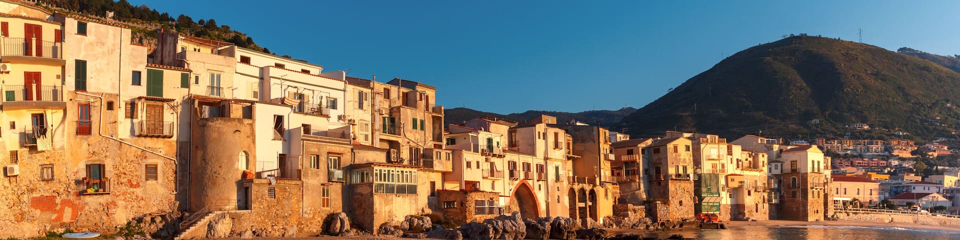Beautiful panorama of the beach and old town of coastal city Cefalu at sunset, Sicily, Italy