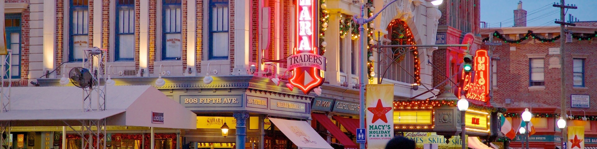 A bustling street with historic buildings, neon signs, and festive decorations.