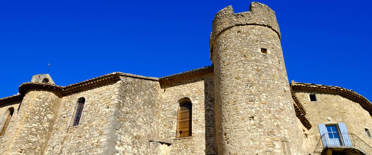 A historic stone building with a prominent tower and arched windows.