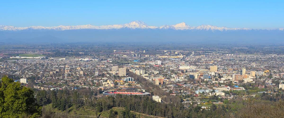 A cityscape with a mountain range in the background.