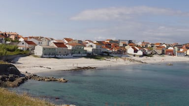 A coastal town with colorful houses, a sandy beach, and a calm sea.