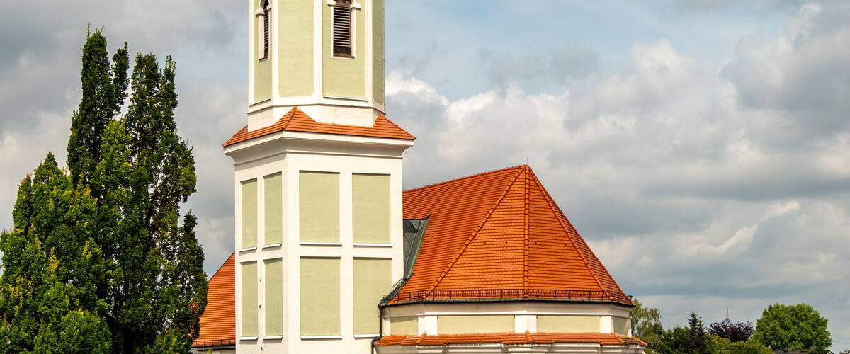 A church with a tall tower and a clock.