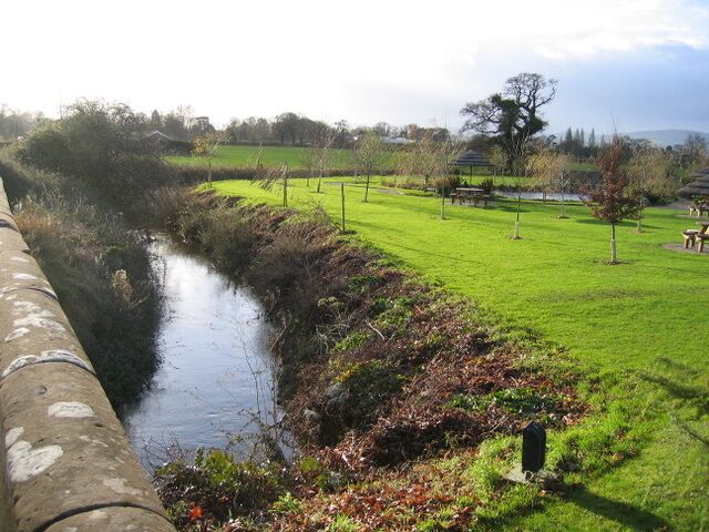 Pulford Brook and the gardens of the Grosvenor Pulford Hotel & Spa Looking over the western parapet of Pulford Bridge towards Pulford Brook. The brook is seen here in winter after its summer growth of weed has been cut back. In late summer the brook is almost hidden from view - see 1465709. On the right are well tended gardens of the Grosvenor Pulford Hotel and Spa.