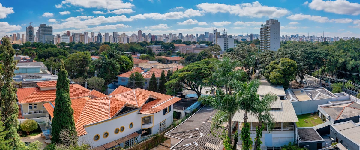 A cityscape with a mix of residential buildings and high-rise buildings under a clear blue sky.
