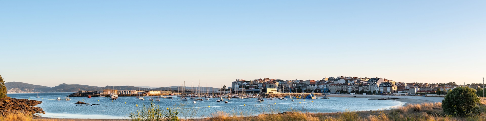 Panorama view of the beach and sport port of Portonovo in the Ria de Pontevedra at dusk, Spain.