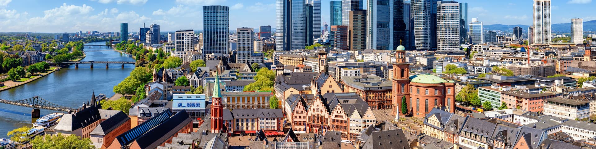 A cityscape with a river, historic buildings, and modern skyscrapers.