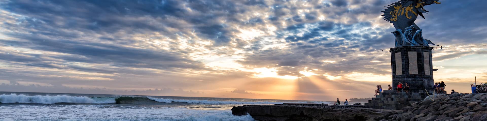 Sun sets behind a sculpture of Gajah Mina on Pererenan beach in Canggu, Bali in Indonesia.