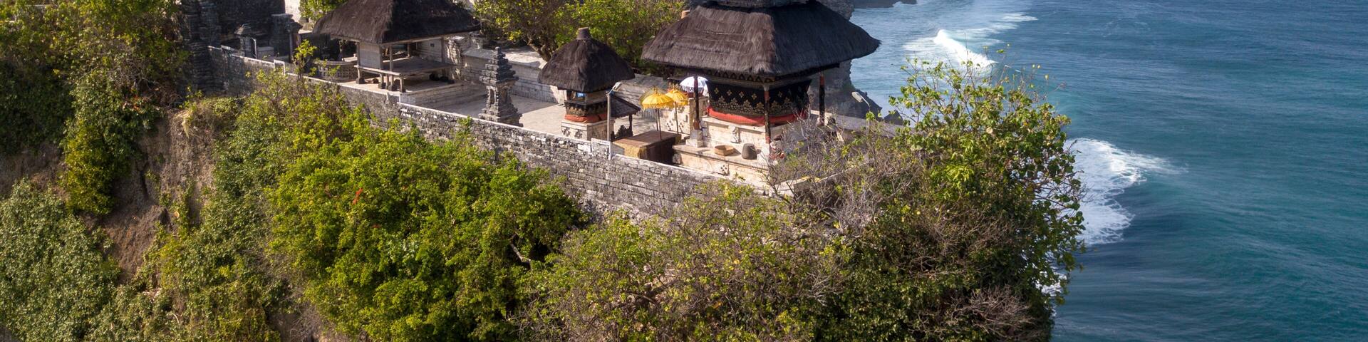 Aerial view at Pura Luhur Uluwatu temple. Stone cliffs, ocean waves and ocean landscape. Bali island, Indonesia.