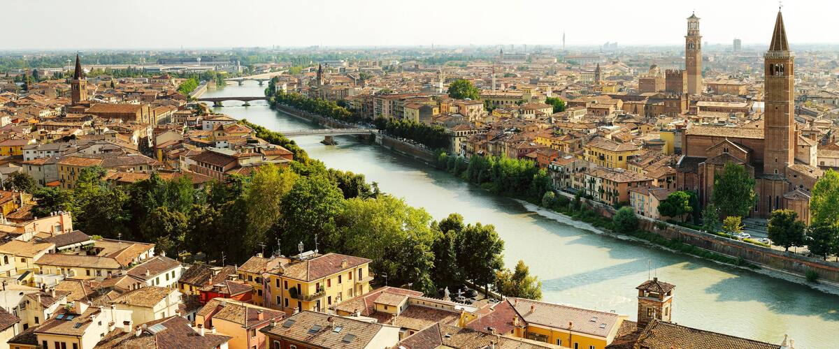 A river flowing through a densely built city with historic architecture and prominent towers.
