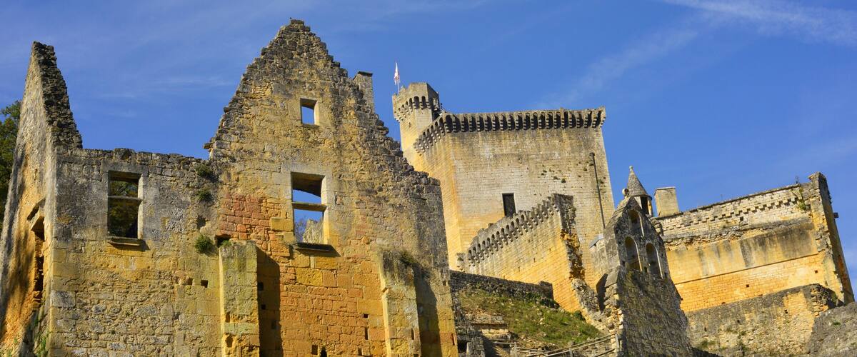 A historic stone castle with crumbling walls and a tall tower.