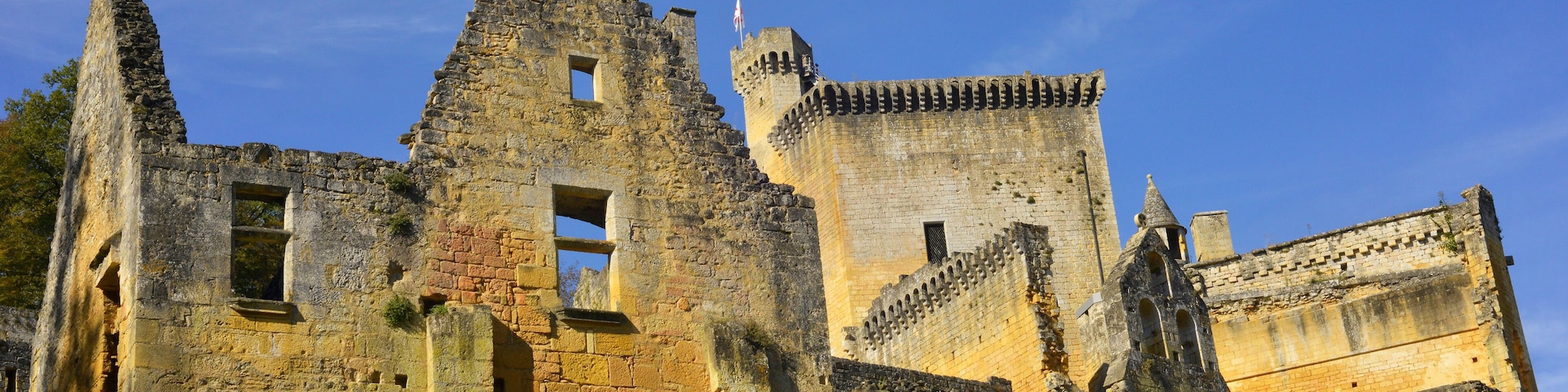 A historic stone castle with crumbling walls and a tall tower.