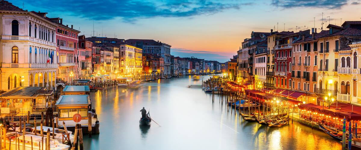 A canal in Venice with boats and colorful buildings along the water.