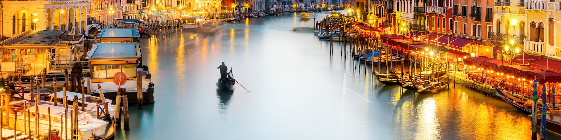 A canal in Venice with boats and colorful buildings along the water.