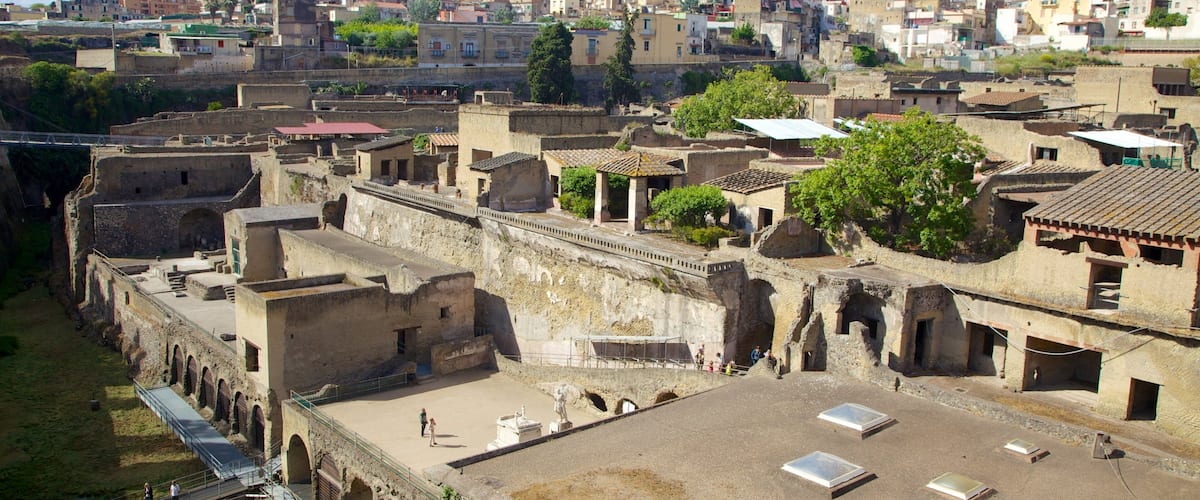 An ancient fortress with ruins and a modern cityscape in the background.