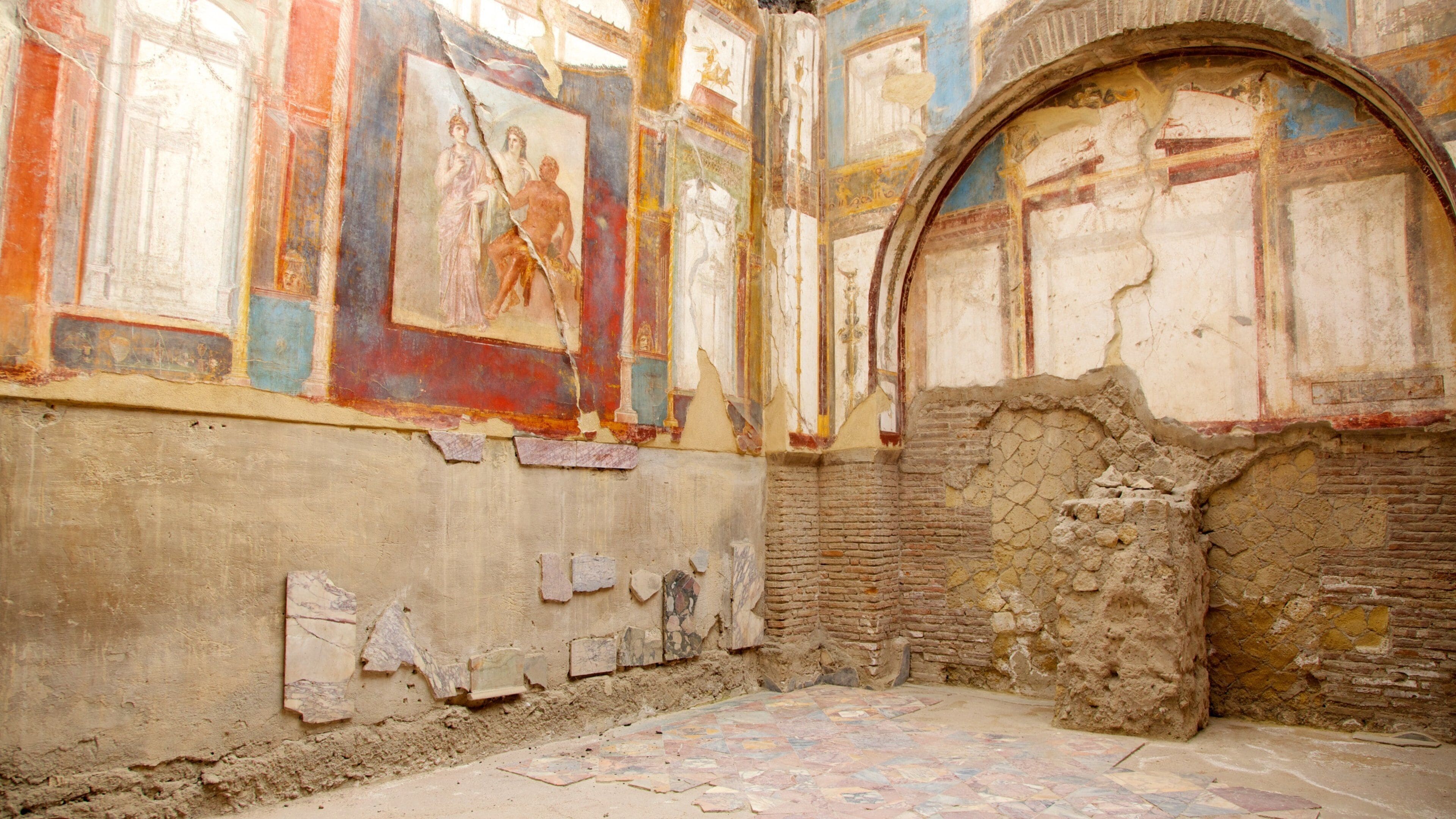 An ancient ruin with frescoes and brick walls.