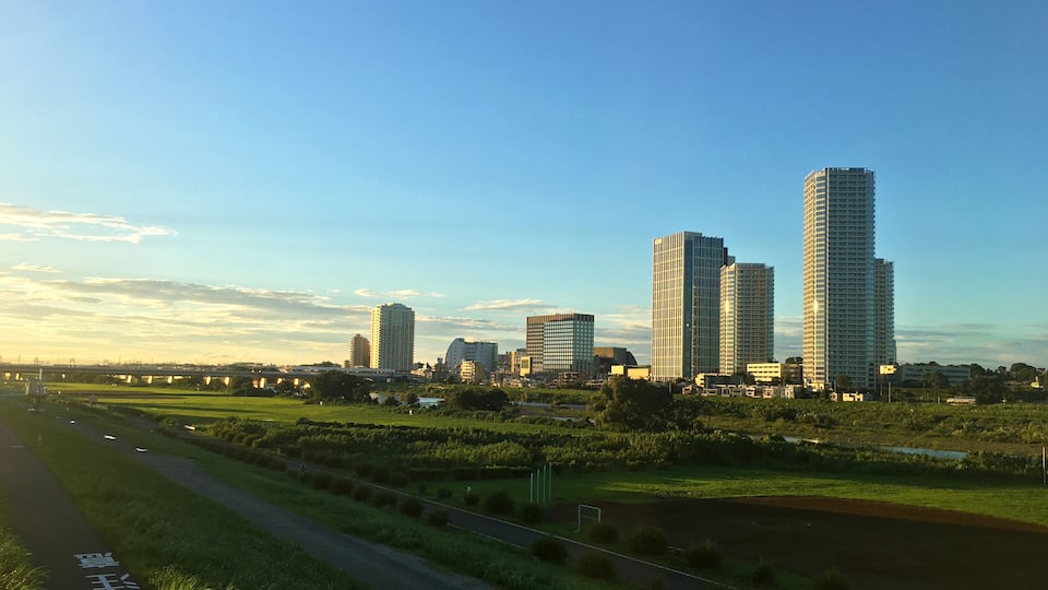Kawasaki riverbed and Futago Tama River buildings illuminated by the setting sun