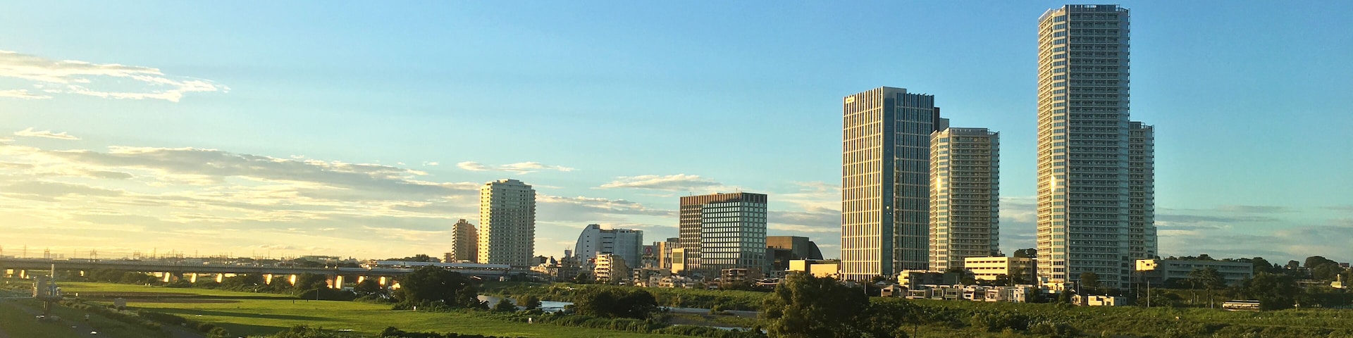 Kawasaki riverbed and Futago Tama River buildings illuminated by the setting sun