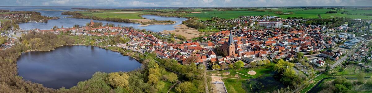 A town with a central church, a lake, and surrounding fields.