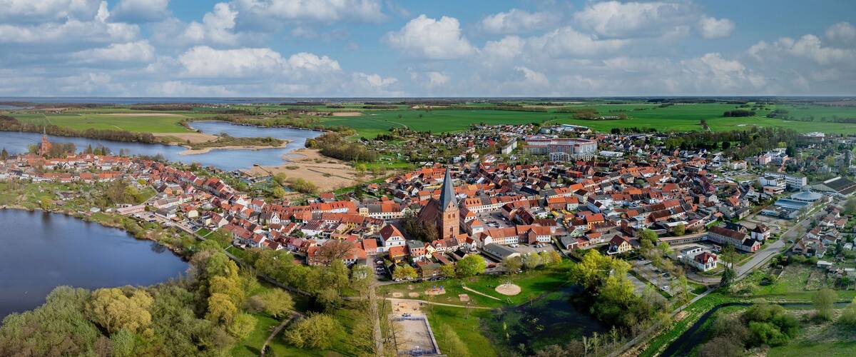 A town with a central church, a lake, and surrounding fields.