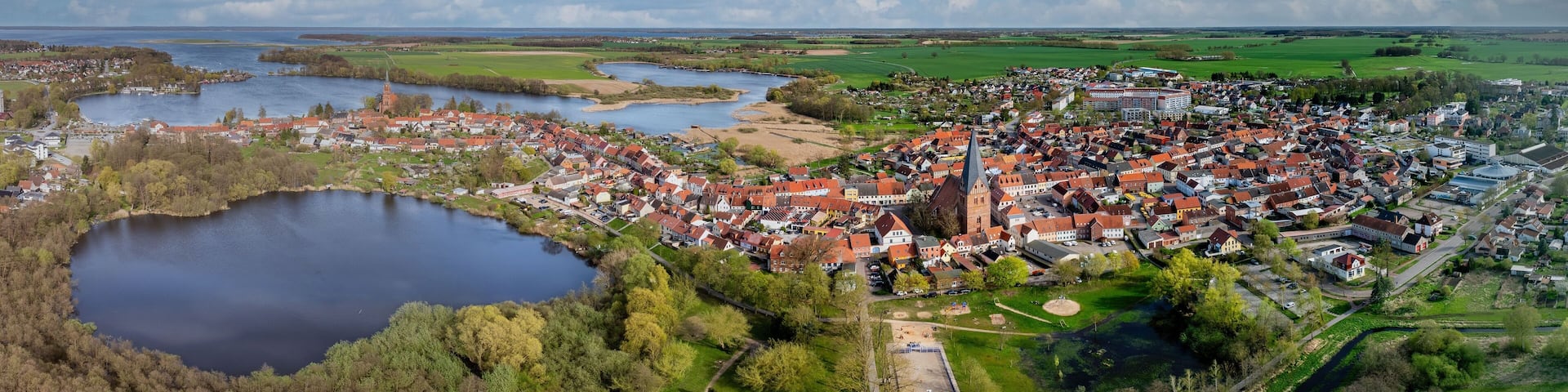 A town with a central church, a lake, and surrounding fields.